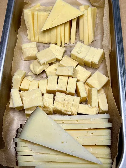 A variety of cheeses cut into triangles and cubes
