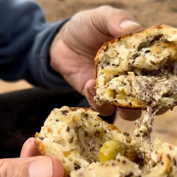 Freshly baked cheese bread rolls topped with green olives