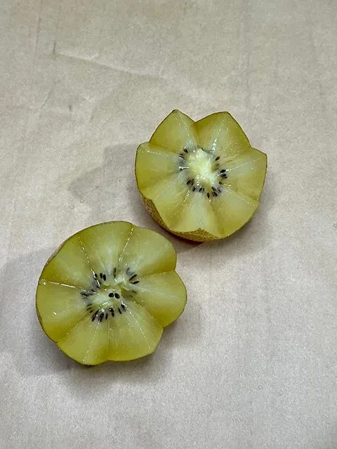 A kiwi fruit cut in half with a zigzag pattern