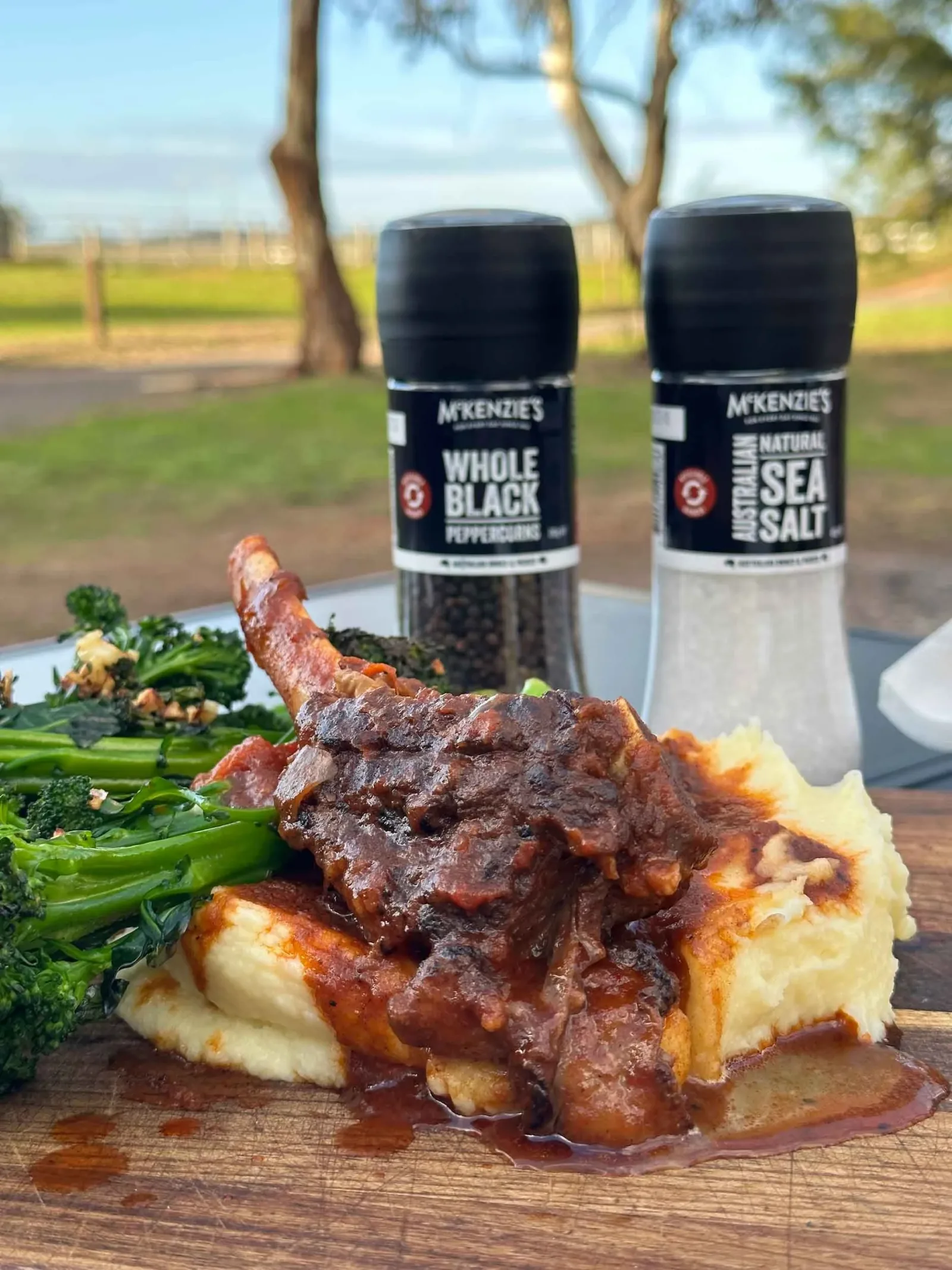 Cooked ribeye on top of mashed potato, served with broccolini