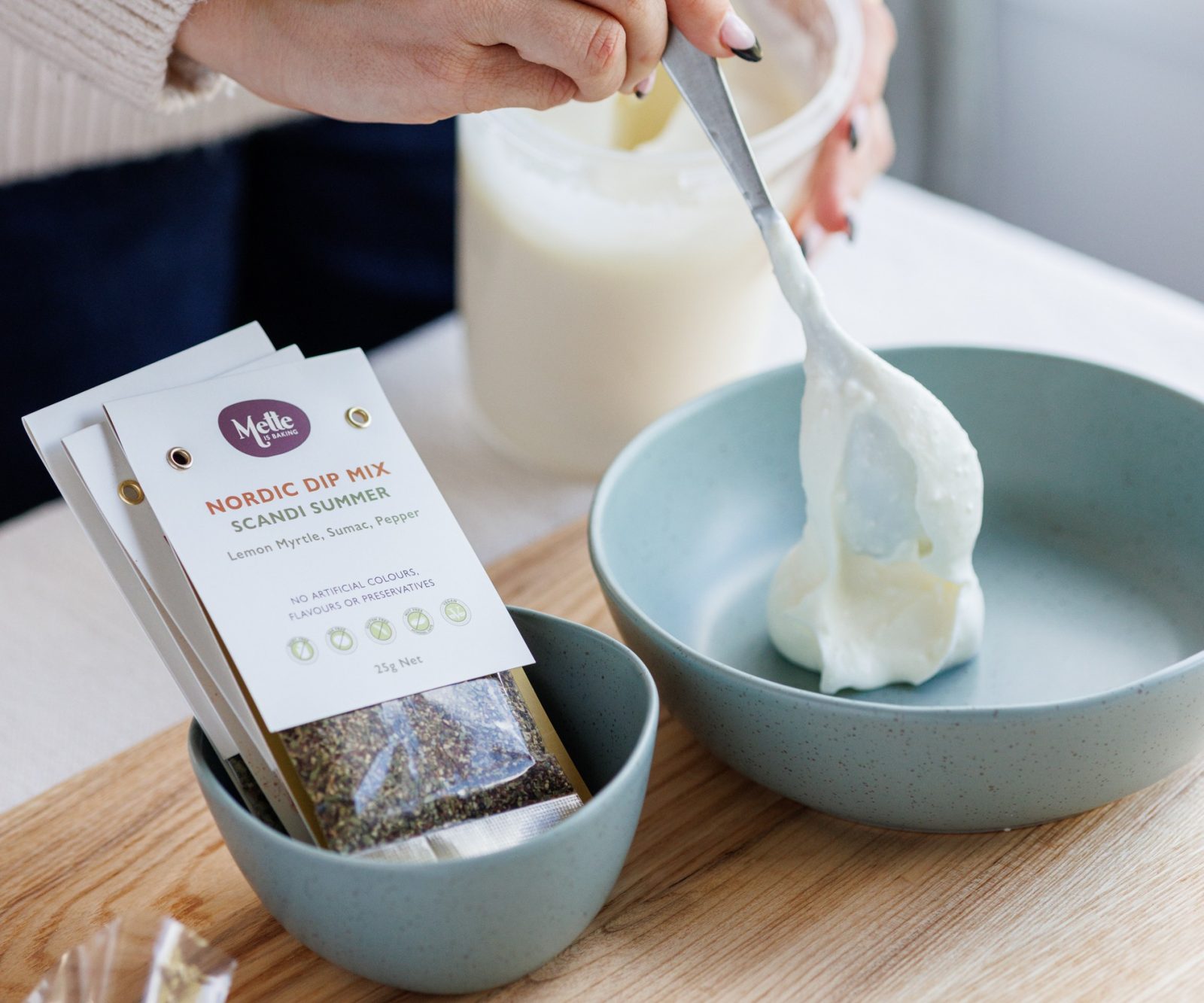 Scandi Summer Nordic dip mix sachets beside a bowl of yoghurt being stirred